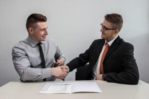 A business owner and a client shaking hands, this exemplifies the differences between lead generation vs lead nurturing