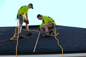 Two roofers on a roof explaining how to generate roofing leads for roofing businesses