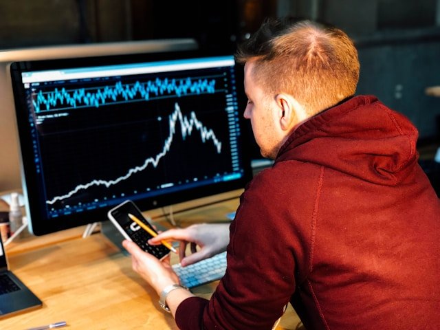 A person looking at a phone sitting at a desk explaining the need for financial advisor lead generation