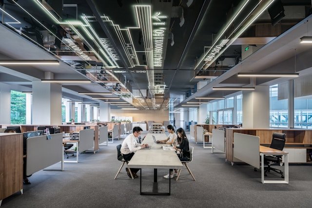 People in an office, sitting at a desk discussing the need for lead generation for consulting companies